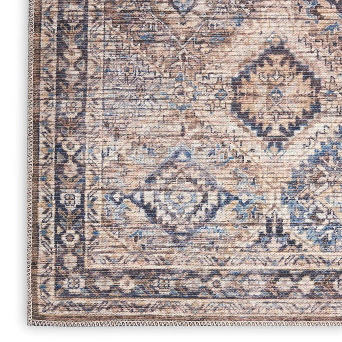 Close-up of blue and beige washable rug with multicolor diamond and line motifs