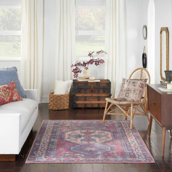 Washable area rug with red, blue, and beige geometric border pattern