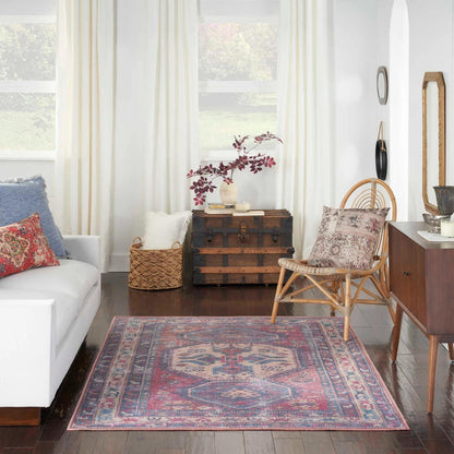 Washable area rug with red, blue, and beige geometric border pattern