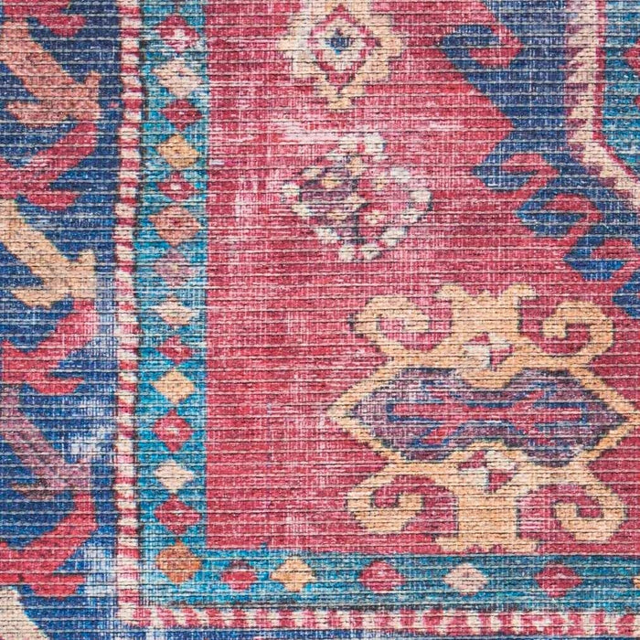 Close-up section of washable area rug with distressed red, blue, and cream geometric motifs