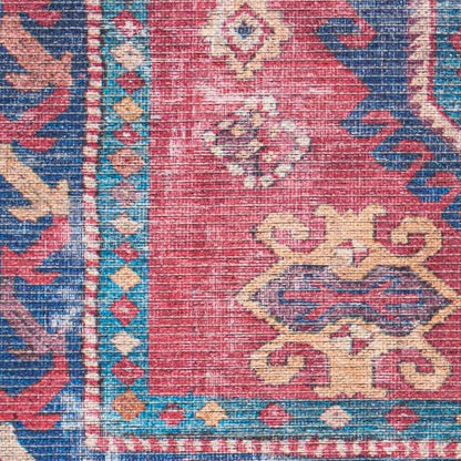 Close-up section of washable area rug with distressed red, blue, and cream geometric motifs