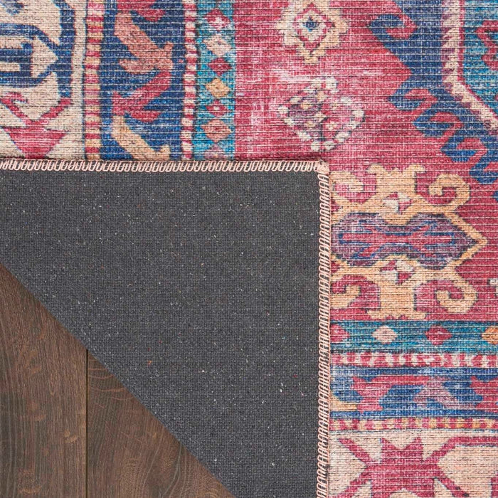 Area rug edge with gray underside and red-blue geometric pattern border