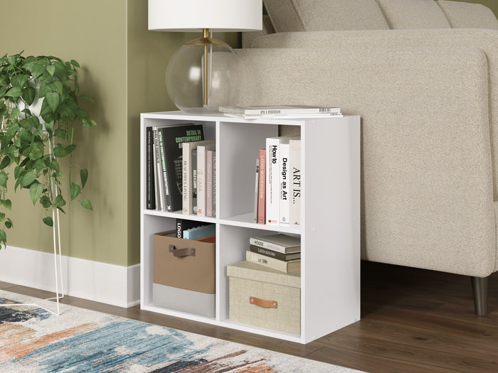 White cube organizer cabinet with open shelves and cubbies holding books and bins