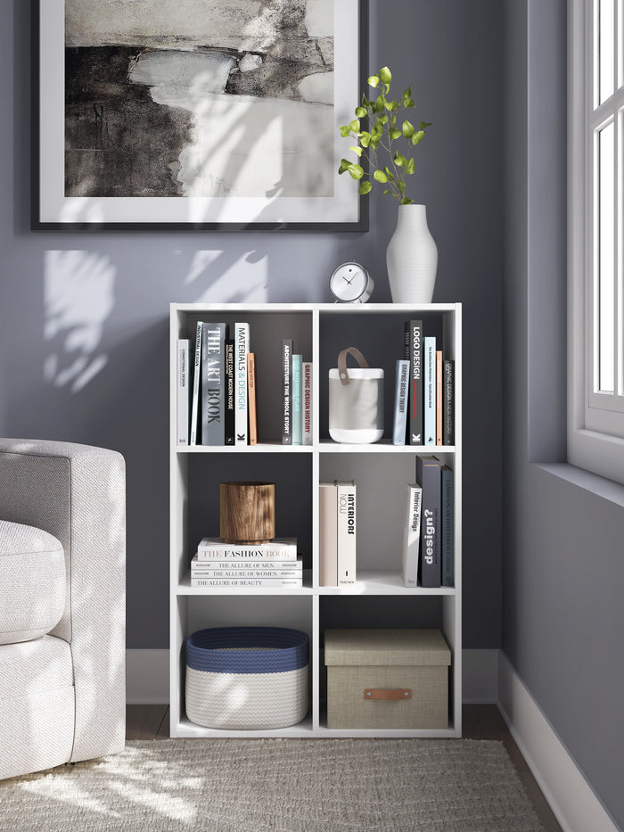 Black cube organizer with open shelves holding books, decor, and storage bins