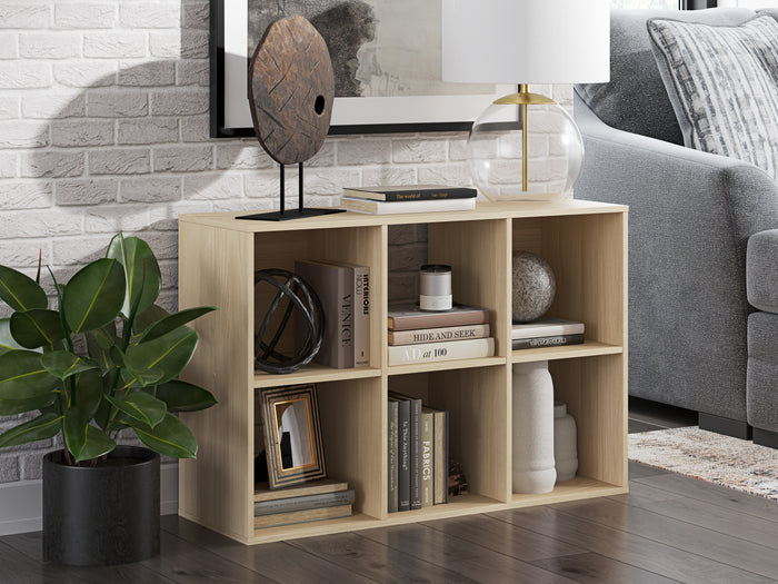 Light tan cube organizer cabinet with open cubbies, styled with books and office items