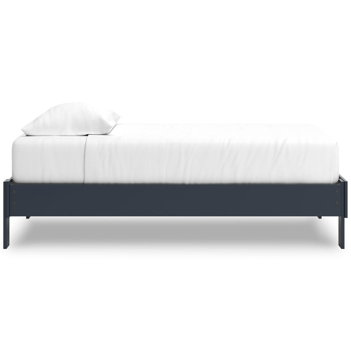 Platform bed with dark blue side rails and white mattress with pillows