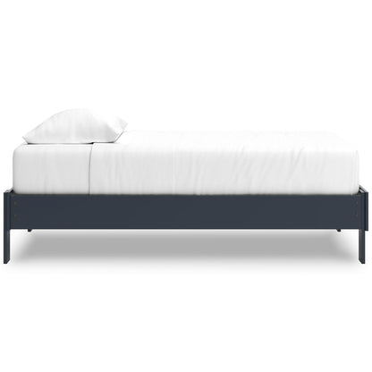 Platform bed with dark blue side rails and white mattress with pillows