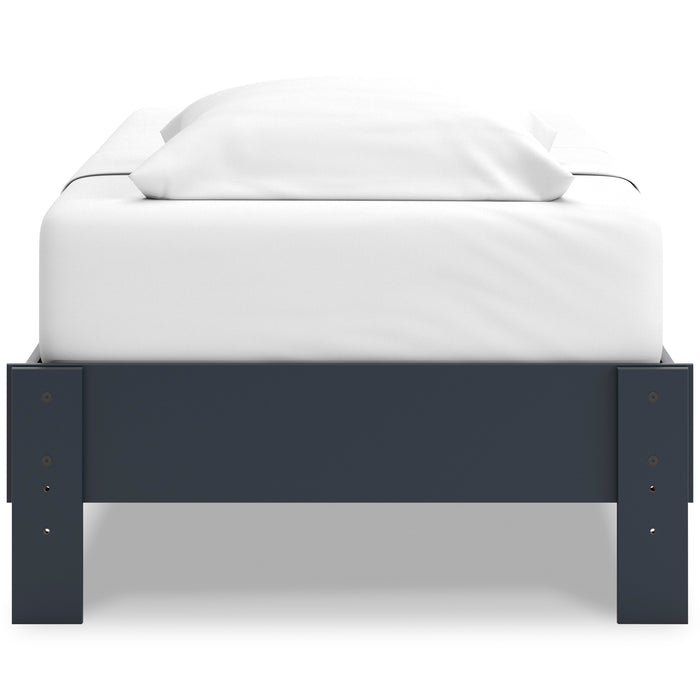 Platform bed with dark blue footboard and white mattress with raised side panels