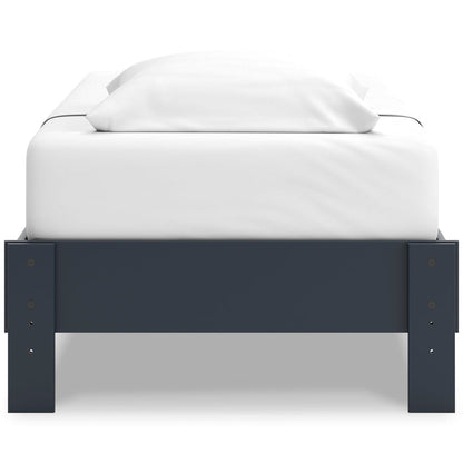 Platform bed with dark blue footboard and white mattress with raised side panels
