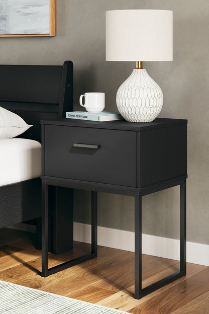 Black nightstand with a single drawer, metal bar pull, and open space below.
