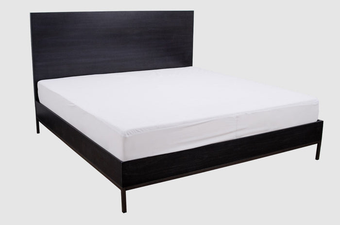 Queen bed with white fitted mattress protector cover on top