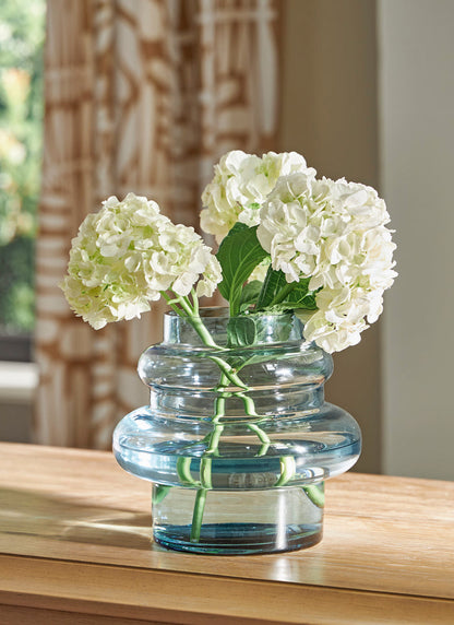 Blue glass vase with hydrangea-style white flowers, clear ribbed design