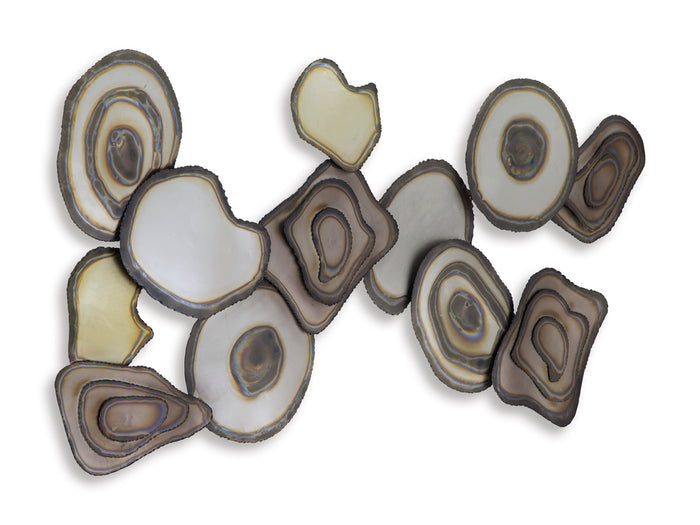 Wall decor sculpture of layered ovals and circles with white, tan, and dark accents