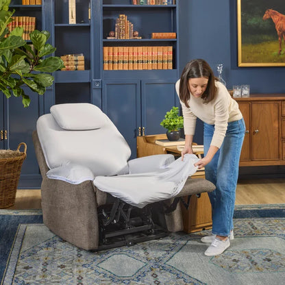 Light gray recliner chair with extended footrest, shown with white sheets being fitted.